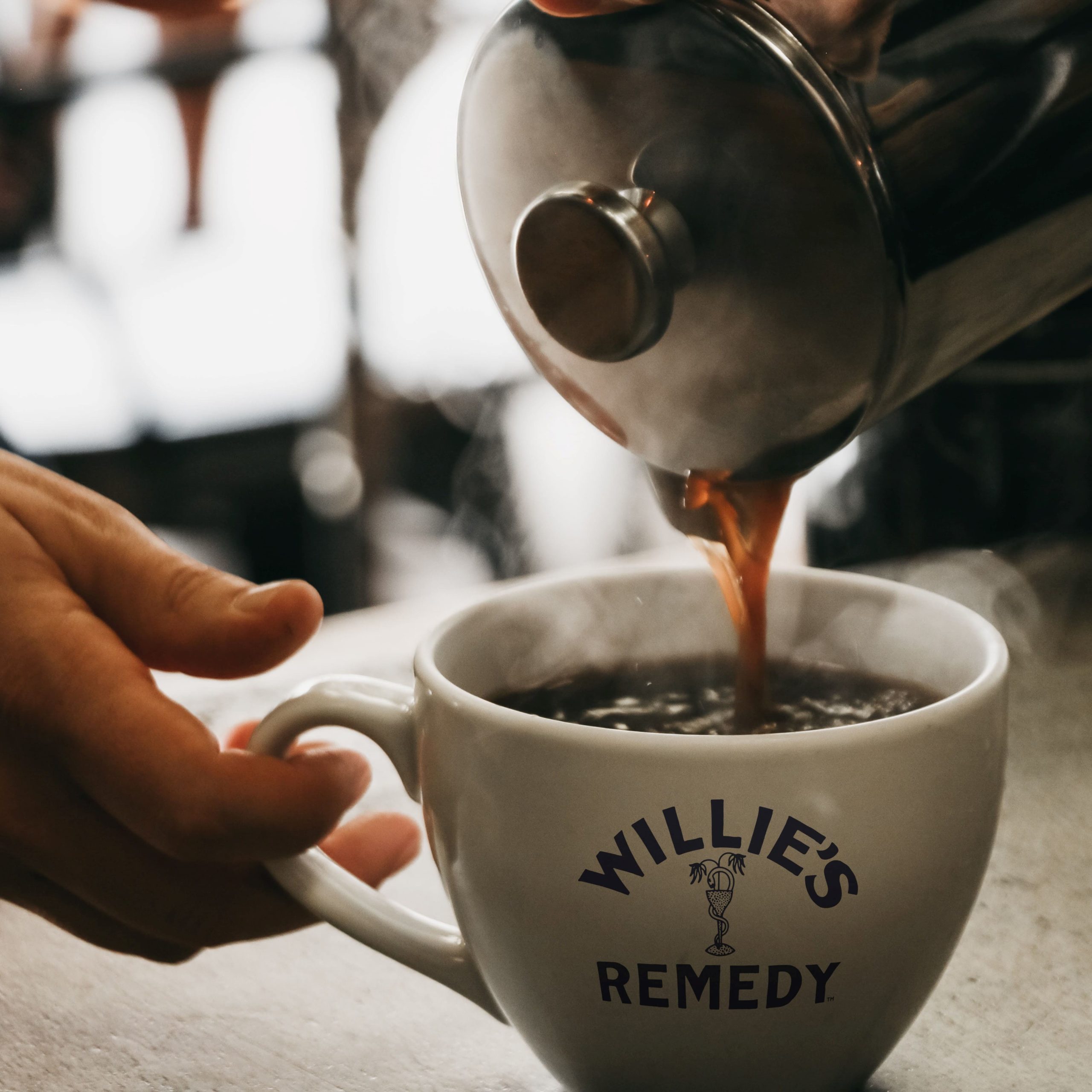 Steaming cup of Willie's Remedy CBD coffee being poured into mug from French Press