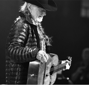 Willie Nelson onstage playing guitar