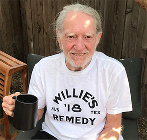 Willie Nelson sitting outside drinking Willie's Remedy Coffee